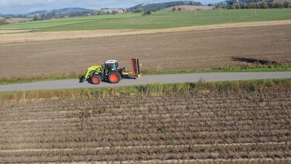 A tractor in a field seen from a drone – a still from the agricultural machinery trials reportage