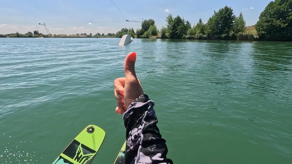 A thumbs-up above the water at a wakepark – a still from a video